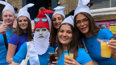 A group of drinkers dressed in Smurf outfits holding drinks 