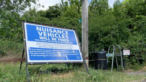 Image of blue Public Spaces Protection sign put up by Medway Council outside the entrance to Coney Banks Recreation Ground in Chatham. The sign says nuisance vehicles will be fined. 