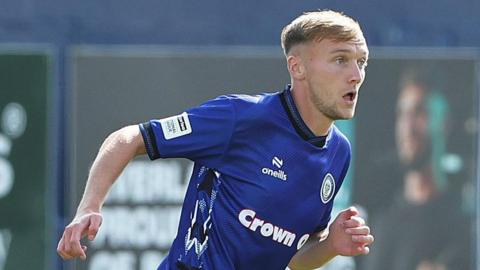 Daniel Moss in the blue shirt of Rochdale in a pre-season friendly