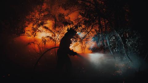 firefighter working to extinguish a forest fire in Oimbra, Ourense, Galicia, Spain, 19 August 2025. 