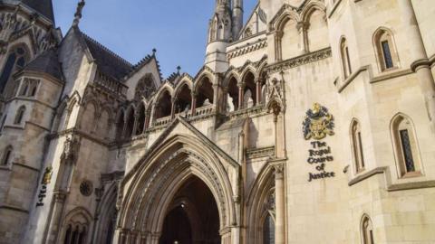 Royal Courts of Justice, an old building with big tower-like walls built in the gothic style