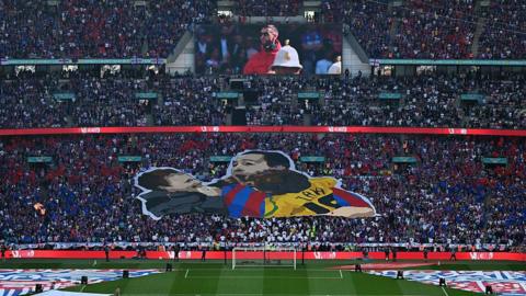 A tifo in the Crystal Palace end at Wembley displaying a man celebrating with his two sons