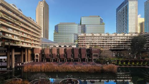 The general area of the brutalist Barbican with an image of the proposed tower blocks in the background superimposed on to the scene