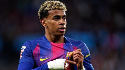 Lamine Yamal holds the Barcelona badge on his shirt