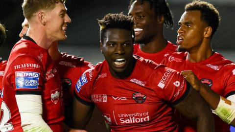 Justin Sangare celebrates scoring a try for Salford Red Devils
