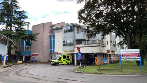 Cheltenham General Hospital from the street, with an ambulance parked outside.