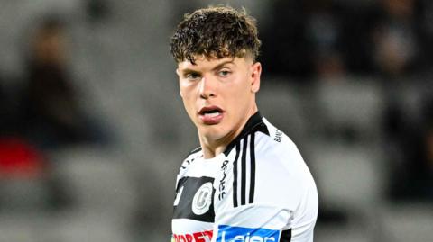 Andrei Coubis, wearing Universitatea Cluj's white and black shirt, during a game against Dinamo Bucahrest in May 2026