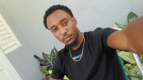 A selfie of Tharel Thompson wearing a black T-shirt and looking into the camera