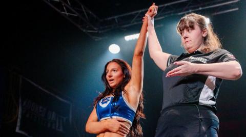 Maddy Morgan is saluted the winner by the referee during a Progress Wrestling event