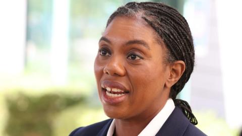 Conservative Party leader Kemi Badenoch in a white shirt and navy suit blazer. 