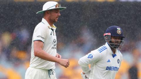 Australia's Josh Hazlewood and India's Rishabh Pant walk off during a rain delay in the third Test