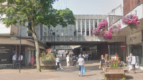 A pedestrianised shopping street with two overbridges