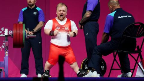 Matthew Harding celebrates his lift in his England powerlifting kit during the Commonwealth Games in Glasgow