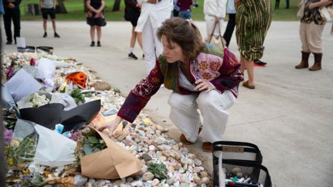 A woman lays flowers at the scene of the Bondi beach shootings