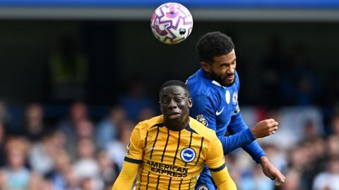 Yankuba Minteh of Brighton contends for the aerial ball with Reece James of Chelsea