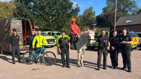Volunteers and emergency service workers - and a horse - at their base set up in a pub car park