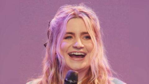 Harriet Kemsley smiles. She has long wavy blonde hair.