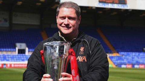 Liverpool Women manager Matt Beard holds the Women's Championship trophy ahead of kick-off between Liverpool and Sheffield United in 2022