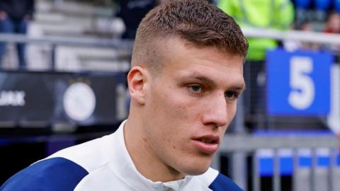 Jakov Medic makes his way out onto the pitch before a game for Ajax against Heerenveen in 2024