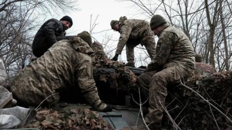 Soldiers gathered around a tank in Ukraine.