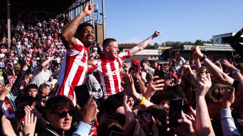 Reeco Hackett-Fairchild and Jack Moylan celebrate with Lincoln fans