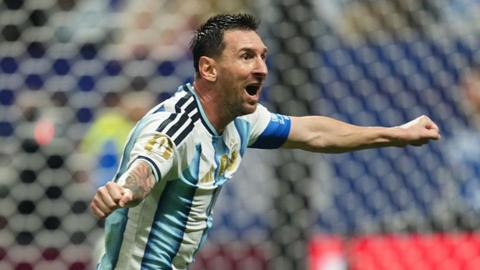Lionel Messi celebrating with his arms out for Argentina