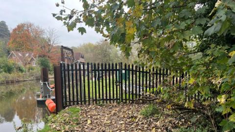 A gate seals off access to the site of the bridge which collapsed in heavy rain 