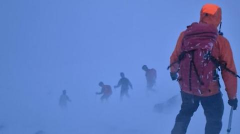 Rescuers in blizzard conditions.