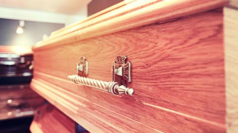 A stock image of a coffin in a funeral home.
