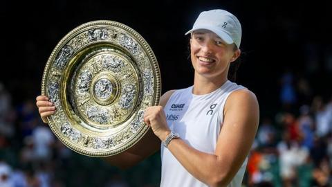 Iga Swiatek holding the Wimbledon women's singles final trophy
