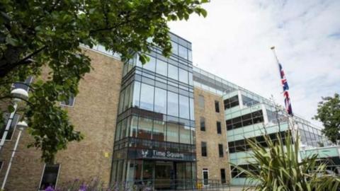 View from the street of Bracknell Forest Council offices. A brick and glass building with a large glass entrance.