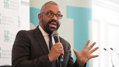 James Cleverly holding a microphone at a think tank event