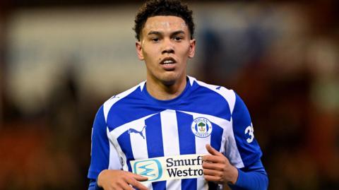 Llyton Chapman in blue and white striped Wigan shirt