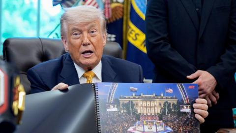 Donald Trump hols up a rendered image of the UFC's White House event