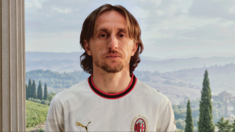 Luka Modric wearing a largely white AC Milan shirt with red and black trim