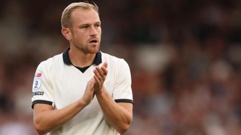 Ryan Croasdale in his white Port Vale shirt claps the fans