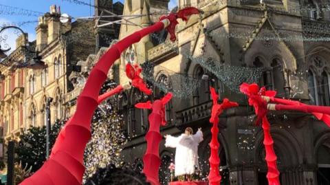 Street theatre performance in Bradford city centre. The red giraffes are 26ft tall