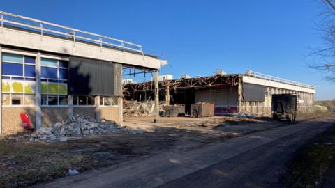 Part of former Delphi factory has been removed, leaving two stand alone buildings, rubble and twisted metal can be seen on the floor.