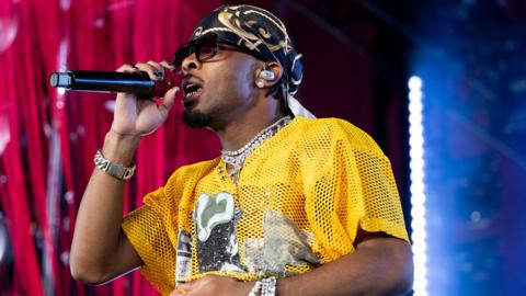 D4VD performing in bright yellow clothing at Coachella festival in 2026