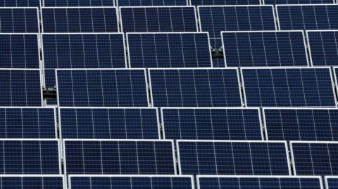 A stock image of solar panels in a solar farm