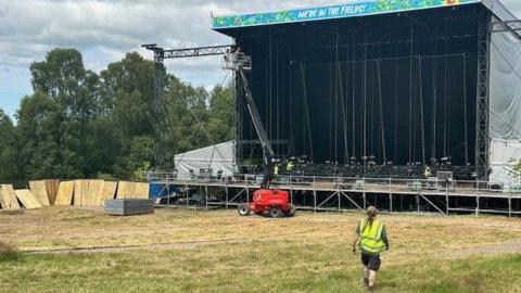 Large performance stage being set up on a field