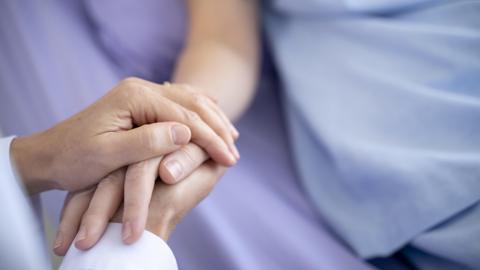 A hand placed on top of someone's hand