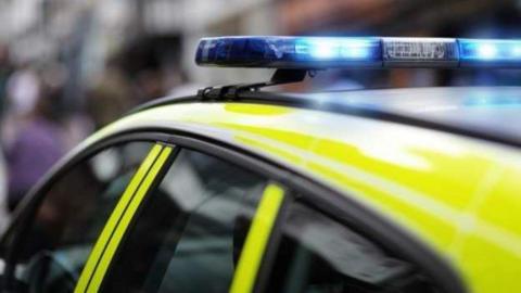 The top of a police car showing its lights flashing blue. 