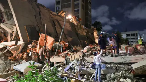 Emergency services work at the site of a collapsed building after an earthquake, in Caracas, Venezuela, June 24, 2026.