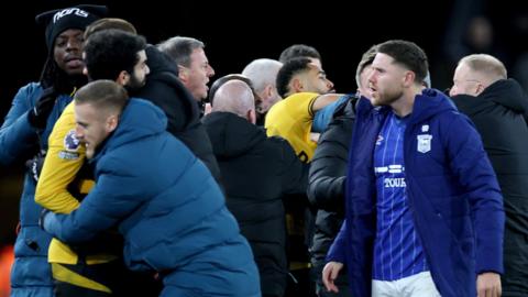 Matheus Cunha clashes with a member of Ipswich's security team.