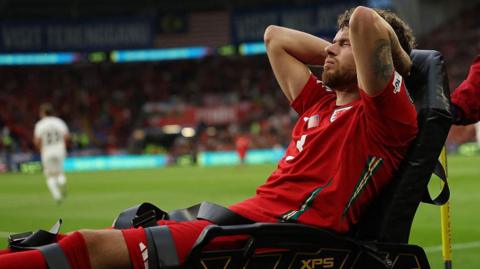 Neco Williams is stretchered off during the first half at Cardiff City Stadium