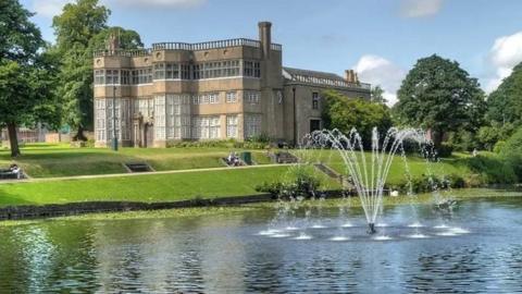 Astley Hall with fountain and lake in front of it - with large grassed gardens 