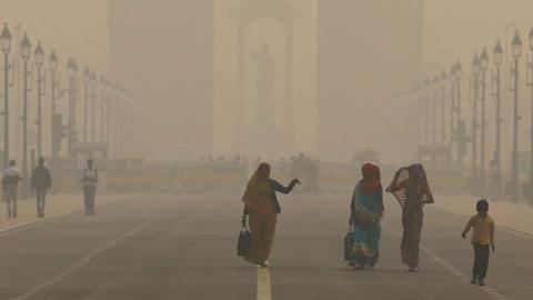 Women walk on a road near India Gate as the sky is enveloped with smog after Delhi's air quality worsened due to air pollution, in New Delhi, India, on 19 November 2024