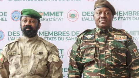 The head of head of Niger's military government General Abdourahamane Tiani (R) and Malian Colonel Assimi Goita (L) pose for a photo as they arrive ahead of the Confederation of Sahel States (AES) summit in Niamey on July 6, 2024.