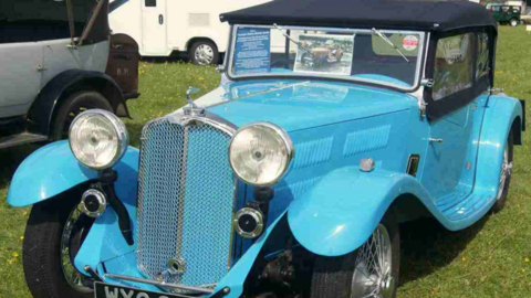 Classic blue vintage motorcar parked on grass